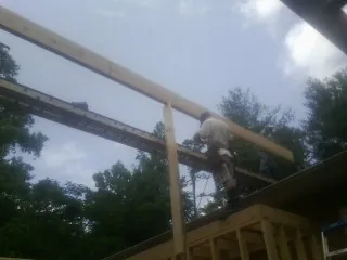 Carpenter setting a ridge beam over a new addition frame — Ice Dam Removal by Roofing Brothers in Glenwood